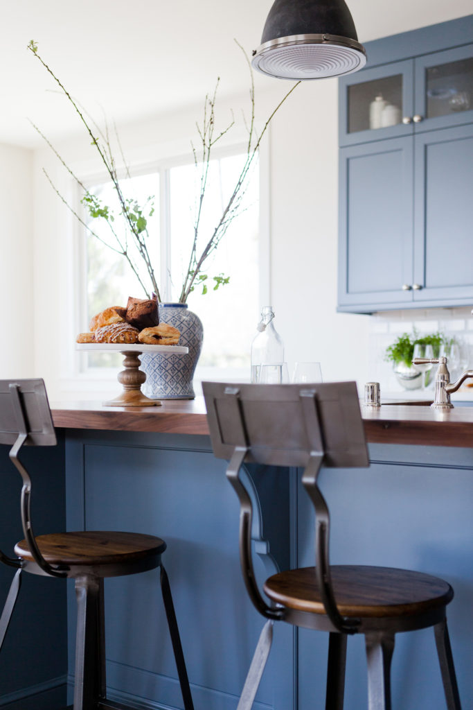 Blue kitchen wood countertop metal barstools white subway tile designed by Kate Lester Interiors 
