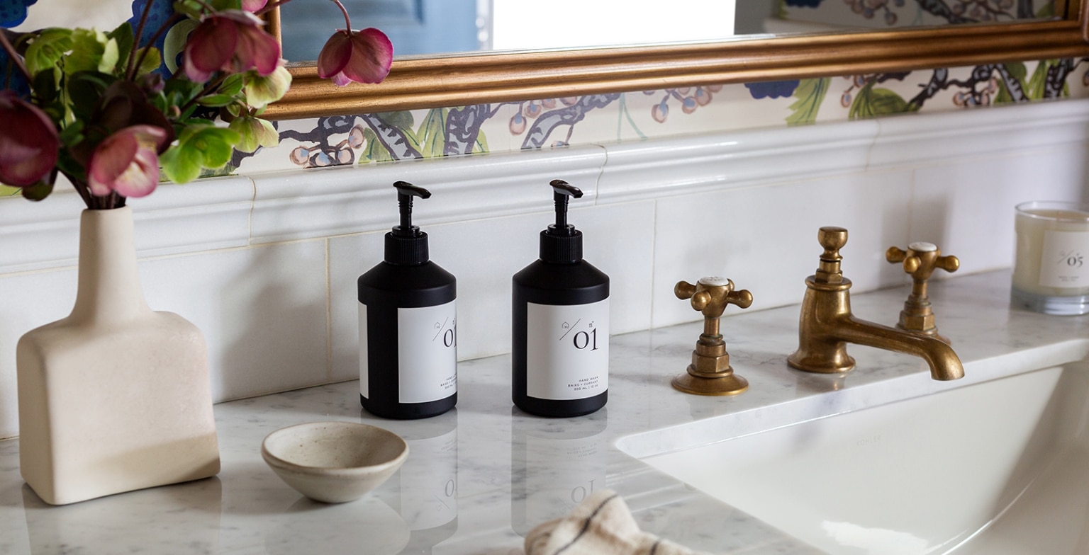 Kate Lester signature hand soap and hand lotion on a marble counter